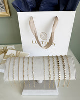 Linked by Lustora chains on a display stand with a Lustora branded gift bag in the background.