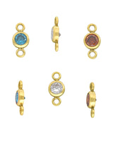 Set of gold permanent jewelry connector charms with gemstones on a white background