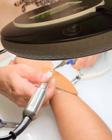 Linked by Lustora™ permanent jewelry weld in process with overhead light