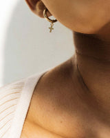Model Wearing 14k Gold-Filled Heart Charm Mini Huggie Hoops