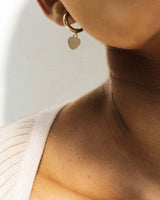Model Wearing 14k Gold-Filled Heart Charm Mini Huggie Hoops