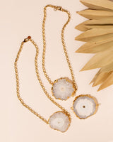 3 Zuri Solar Quartz necklaces flat lay on peach