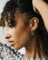 Tightly cropped photo of model wearing large Cami Oval Hoops in Sterling silver