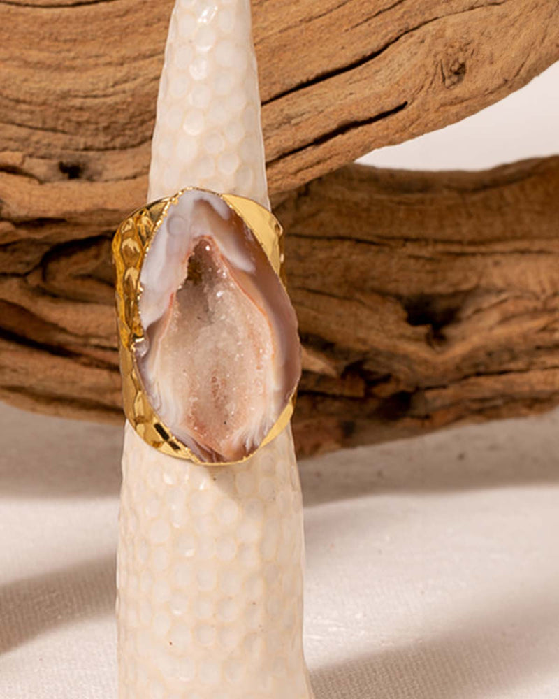 Close up of a Natural Geode Cigar Ring on a Ring Stand with a Branch in the Background