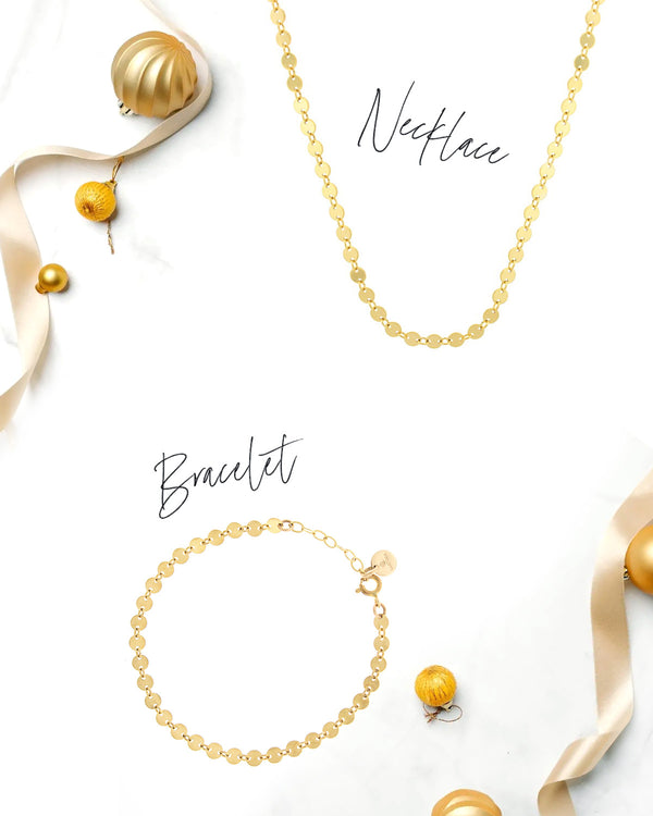 Simone necklace and bracelet in 14k gold finish with ribbons and ornaments on a white background