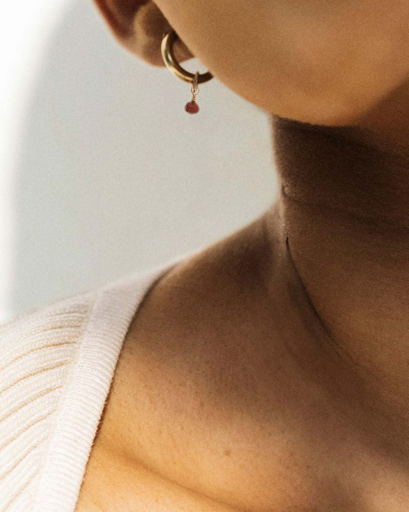 Model Wearing a Mini Huggie Hoop With a Charm Gemstone